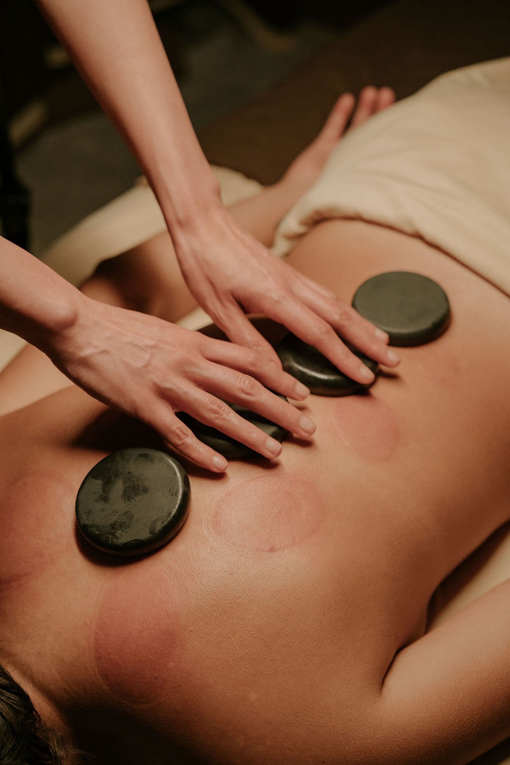 Heated basalt stones arranged for hot stone massage therapy at Siam Ivory